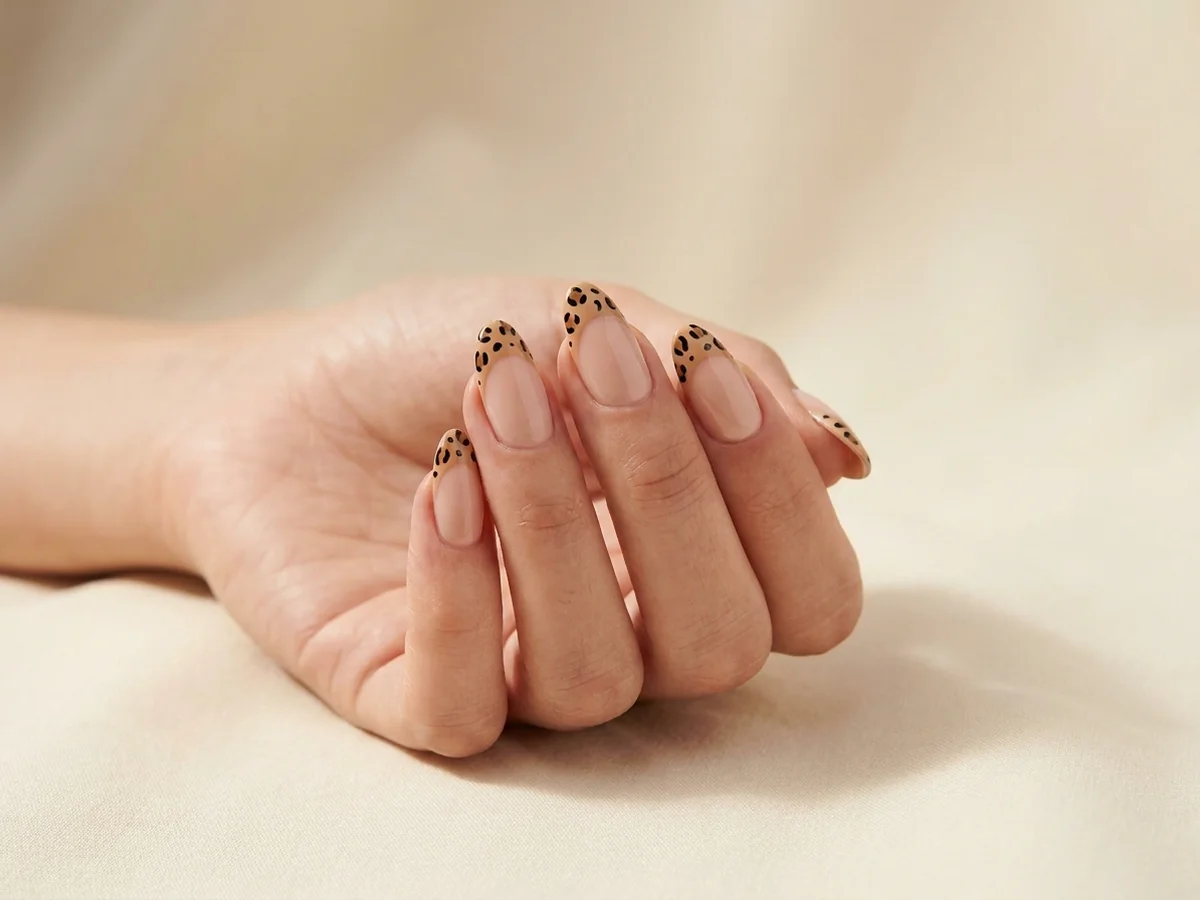 Nude almond nails with leopard-print French tips