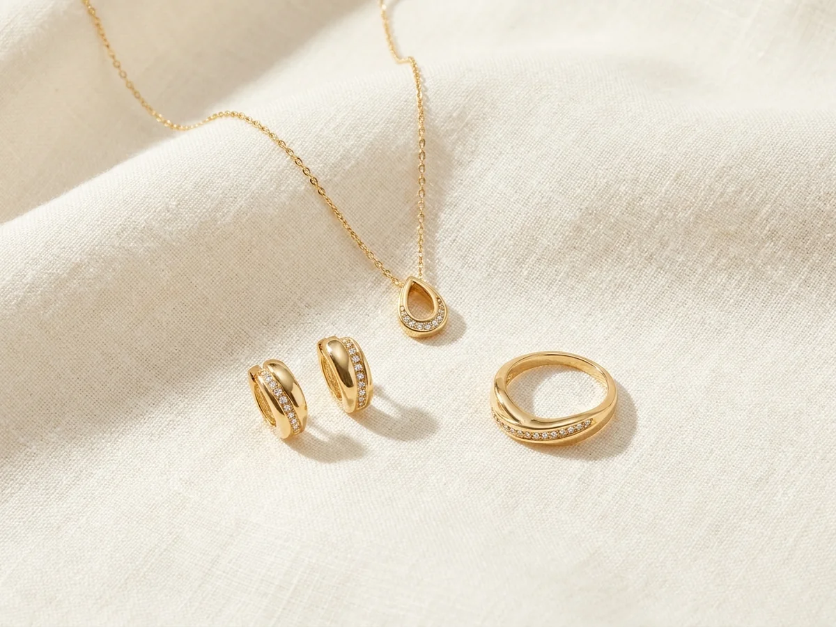 Gold-tone teardrop necklace with coordinated curved earrings and ring